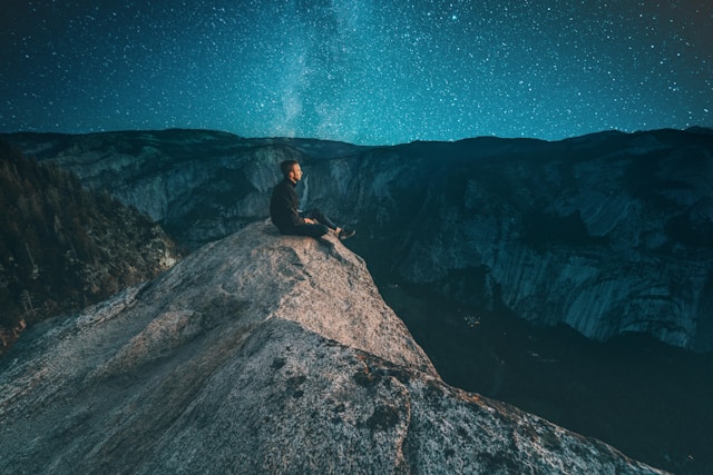 綺麗な星空の下で景色を眺める男性